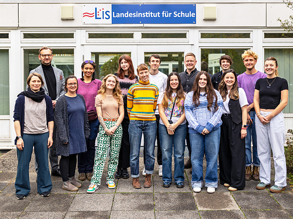 Eine Gruppe von Fremdsprachenassistenzkräften steht vor dem Haupteingang des Landesinstituts für Schule