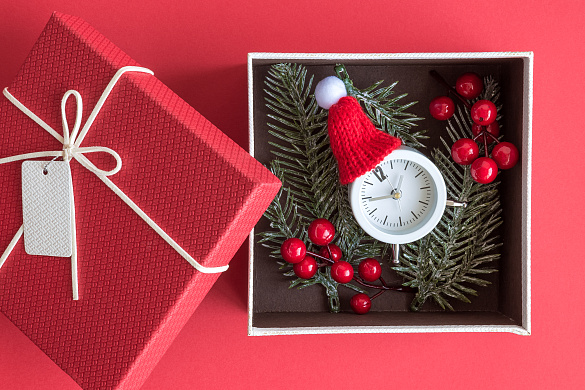 geöffnetes Weihnachtsgeschenk mit Uhr, die auf zehn vor zwei steht