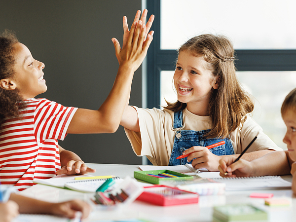 Zwei Schulkinder klatschen sich ab